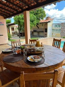 a wooden table with plates of food on it at Casa Recanto Damasco in Coqueiro +3 photos