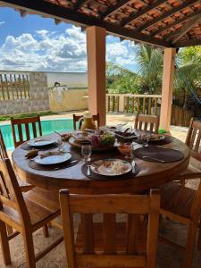a wooden table with plates of food on it at Casa Recanto Damasco in Coqueiro