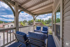 a porch with two blue chairs on a balcony at Downhill Lodge Condominium in Lake Placid