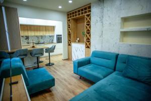 a living room with a blue couch and a kitchen at Portunata Penthouse - Novalja Center in Novalja