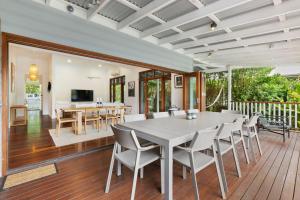 Un comedor y una sala de estar con mesa y sillas. en Margaret, en Byron Bay