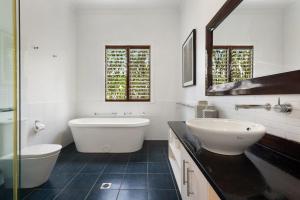 Un baño con dos lavabos, una bañera y un espejo. en Margaret, en Byron Bay 14 fotos más