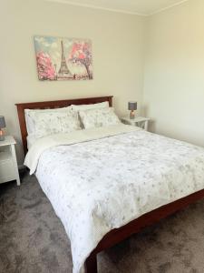 a bedroom with a bed and two night stands at Renovated Entire 2BR Flat, Comfort, Scenic Views, Free Parking & 10 min to Ferry in Wellington