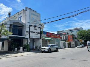 a white car parked on the side of a street at Lion Homestay Huế in Thôn Lại Thê