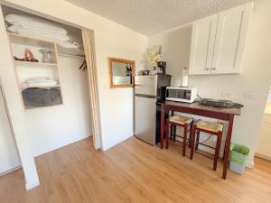 a small kitchen with a table and a refrigerator at Mellow Kuhio Village Studio condo in Honolulu