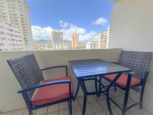a table and chairs on a balcony with a view at Mellow Kuhio Village Studio condo in Honolulu