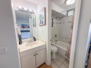 a white bathroom with a sink and a toilet at Mellow Kuhio Village Studio condo in Honolulu +14 photos