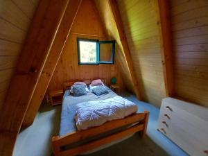 ein Schlafzimmer in einem Blockhaus mit einem Bett in der Unterkunft Chalet individuel chaleureux au pied des pistes - FR-1-787-128 in Laveissière