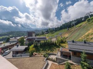 a view of a town with buildings and a hill at Appartement moderne Courchevel 1550, 4 personnes, parking, wifi - FR-1-631-234 in Courchevel