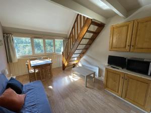 un soggiorno con scala e una sala da pranzo di Charmant Duplex pour 5 pers., Wi-Fi & Parking au Lioran - FR-1-787-108 a Laveissière