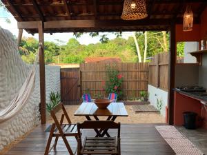 a patio with a table and chairs and a hammock at Canto Carauari Pousada in Alter do Chao