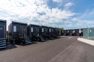 a row of black containers parked in a parking lot at HOTEL R9 The Yard Acrossplazakanuma in Kanuma