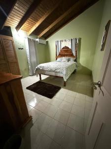 una camera da letto con un letto nell'angolo di una stanza di Peaceful Tropical 2-Bedroom Villa a Montego Bay