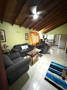 un soggiorno con due divani e un tavolo di Peaceful Tropical 2-Bedroom Villa a Montego Bay