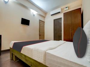 ein Schlafzimmer mit einem Bett und einem Fernseher an der Wand in der Unterkunft Collection O Aqualura Verem Rd in Goa