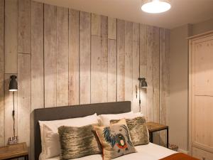 1 dormitorio con 1 cama con pared de madera en Lancaster City Apartment, en Lancaster