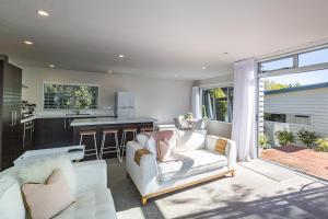 een woonkamer met een bank en een keuken bij Modern on Miro in Ohakune