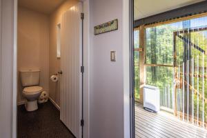 een badkamer met een toilet en een raam bij Modern on Miro in Ohakune +23 foto's