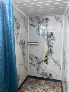 a shower in a bathroom with a marble wall at уют in Cholpon-Ata
