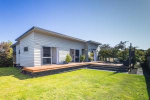een klein wit huis met een grote tuin bij Modern on Miro in Ohakune
