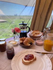 a table with a plate of pastries and juice at 7 Borreguitos GUESTHOUSE in Cusco