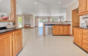 a large kitchen with wooden cabinets and appliances at Charmante Maison Avec Piscine in La Douze +24 photos