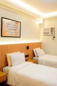 a hotel room with two beds and a picture on the wall at YMCA Makati in Manila