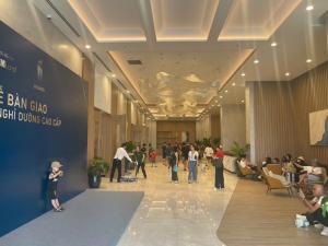 eine Gruppe von Menschen steht in einer Lobby mit einer Menschenmenge in der Unterkunft ICON40 HomeStay Hạ Long in Hạ Long + 11 Fotos