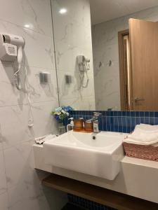 ein Badezimmer mit einem weißen Waschbecken und einem Spiegel in der Unterkunft ICON40 HomeStay Hạ Long in Hạ Long