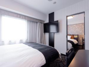 a hotel room with a bed and a mirror at APA Hotel Nagoya Sakae Ekimae EXCELLENT in Nagoya