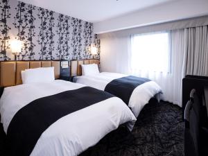 a hotel room with two beds and a window at APA Hotel Nagoya Sakae Ekimae EXCELLENT in Nagoya