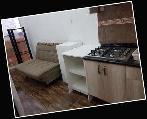 a kitchen with a stove and a couch in it at Parque Residencial Bello Departamento 204 - rentaflex in Mexico City