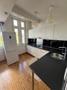 une cuisine avec des armoires blanches et un comptoir noir dans l'établissement Duplex sympa Verviers, à Verviers