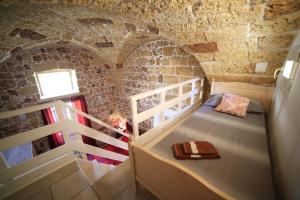 Habitación con escalera y cama en un edificio en La Corte Delle Sterne, en Morciano di Leuca