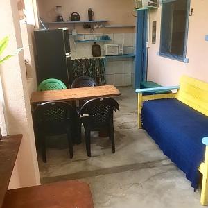 a room with a table and chairs and a bed at Residencial Caetanos - 5 casas em Arraial D'ajuda in Porto Seguro