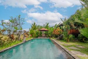 a swimming pool in front of a villa at Precious Journey Retreat in Ubud