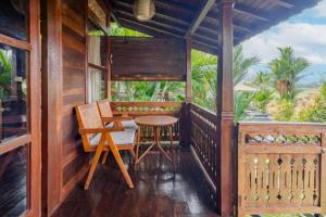 a porch of a house with a table and chairs at Precious Journey Retreat in Ubud