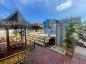 a patio with benches and a staircase and a building at Bangsaray Beach Resort in Bang Sare