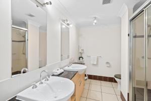 a bathroom with two sinks and a shower at Cairns City Apartments in Cairns