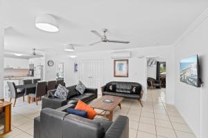 a living room with couches and a table at Cairns City Apartments in Cairns