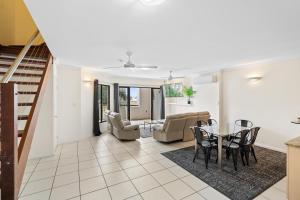 a living room with a table and chairs at Cairns City Apartments in Cairns