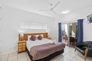 a bedroom with a bed and a chair at Cairns City Apartments in Cairns