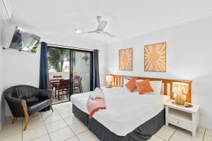 a bedroom with a bed and a chair and a table at Cairns City Apartments in Cairns
