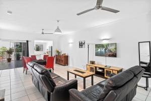 a living room with a couch and a table at Cairns City Apartments in Cairns