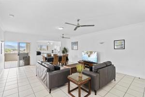 a living room with two couches and a table at Cairns City Apartments in Cairns