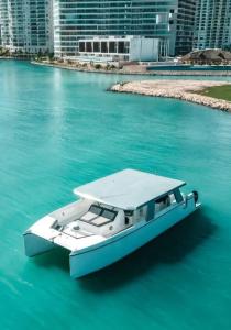 un barco en el agua con edificios en el fondo en Barco privado de lujo para tu familia y amigos en Cancun-isla mujeres, en Cancún