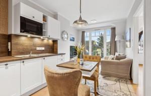 eine Küche und ein Wohnzimmer mit Tisch und Stühlen in der Unterkunft Baltischer Hof Apartment 49 in Boltenhagen