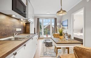 eine Küche mit einem Waschbecken und ein Esszimmer mit einem Tisch in der Unterkunft Baltischer Hof Apartment 49 in Boltenhagen