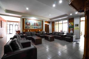 una sala de estar con sofás de cuero y una pintura en Puri Saras Syariah, en Bongkor 1