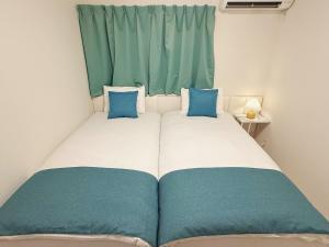 1 cama con 2 almohadas azules en una habitación en solf 世冨慶, en Nago 40 fotos más